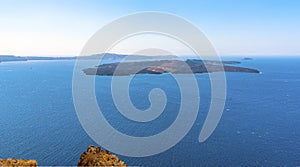 A view from Skaros Rock, Santorini towards the volcanic island of Nea Kameni