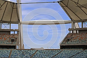 VIEW OF SKY THROUGH BEAMS OF ARCH ACROSS MOSES MABHIDA STADIUM DISPLAYING ROWS OF SEATS IN THE STADIUM