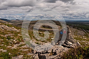 A view of Sliabh Rua, Red Mountain  from  Mullaghmore Mountain  in The Burren National Park with the signs for the various walking