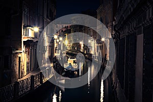 View into a small canal in Venice at night