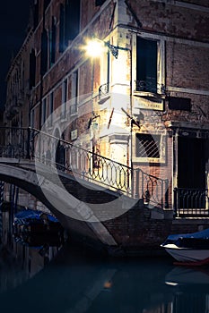 View into a small canal in Venice at night