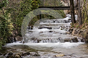 View of small cascading waterfalls under a bridge
