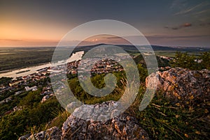 View of Small City and River with Rocks in Foreground