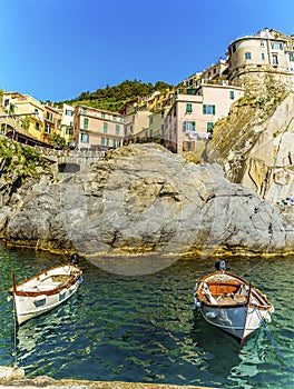 A view of small fishing boats moored in front of the village of Manarola, Cinque Terre, Italy