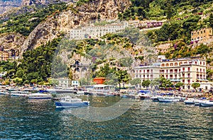 View of small haven of Amalfi village with tiny beach and colorful houses located on rock. Amalfi coast, Salerno, Campania, Italy