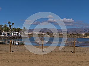 View of small lagoon La Charca in Meloneras, part of Maspalomas, southern Gran Canaria, Spain with fence in front. photo