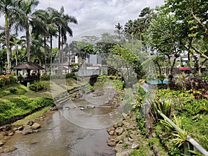 View of a small river flowing through a tropical garden in a luxury hotel