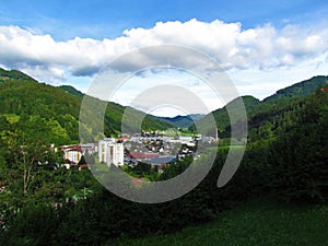View of small town of Zelezniki in Selska dolina in Gorenjska region of Slovenia surrounded by forest covered hills photo