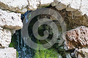 View of a small waterfall flowing near moss and stones in  Schwetzingen, Germany