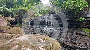 View of a small waterfall in the middle of the forest during the day
