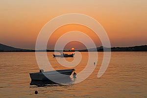 View of small, wooden fishing boats, Aegean sea and landscape at sunset captured in Ayvalik