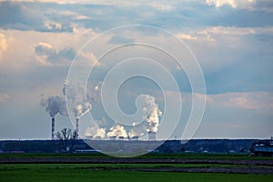 A view of the smoking chimneys of a distant coal-fired power plant on the horizon.