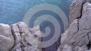 View of smooth sea or ocean surface from above through crevice in rock.