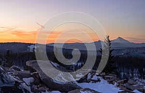 View of snow-capped mountain peaks during a orange sunset