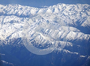 View of the snow-capped peaks of the Main Caucasian Range from the window of a flying plane