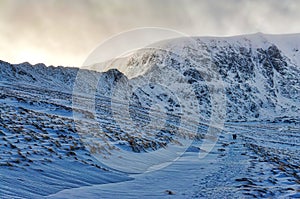 A view of a snow covered Helvellyn from the path to Red Tarn.