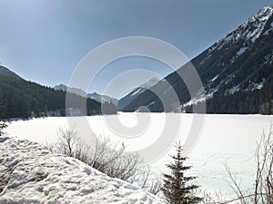 A view of the snow covered mountains and frozen river on Lillooet Lake Road