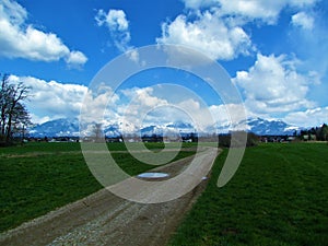 View of snow covered mountains of Kamnik-Savinja alps, Slovenia and fields in front