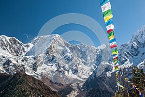 View of snow covered range of Mount Manaslu and prayer flags 8 156 meters with clouds in Himalayas, sunny day at Manaslu Glacier