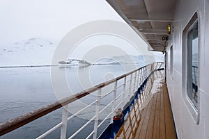 View of snow covered shoreline from outside deck of cruise ship, Antarctica