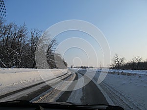 View of the snow-covered track from the windshield of the car