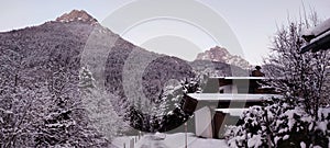 View of a snowy house and snowy nature in the Tyrolean Alps, with mountain peaks in the background