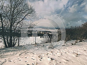 view of the snowy town of Kežmarok, where the High Tatras are the big mountains in Slovakia in the background.