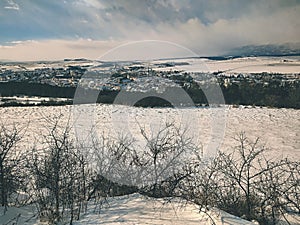 view of the snowy town of Kežmarok, where the High Tatras are the big mountains in Slovakia in the background.