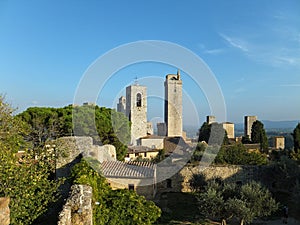 View of some of the towers of San Gimignano, Italy against blue sky, taken from the Parco della Rocca