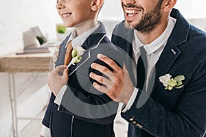 View of son and dad in jackets with boutonnieres