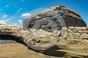 View of the south coast of El Medano. Old military bunker with two embrasures towering right at the seashore. Bright blue sky,