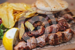 View of Souvlaki on a plate - traditional greek cuisine dish with grilled bbq chicken with french fries and tzatziki sauce served