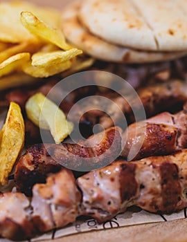 View of Souvlaki on a plate - traditional greek cuisine dish with grilled bbq chicken with french fries and tzatziki sauce served