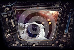 View from a spaceship window with an astronaut knocking starry bokeh background Elements of this image furnished by NASA