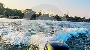 View from a speed motorboat of the engine making a wake in the river.