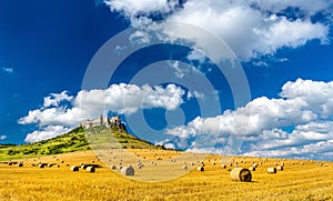 Pohled na Spišský hrad a pole s kulatými balíky na Slovensku, střední Evropa
