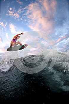 View of sports guy riding wave doing jumps and tricks on the surf style wakeboard