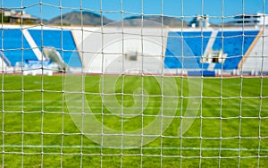 View of the sports stadium through the net of the football goal