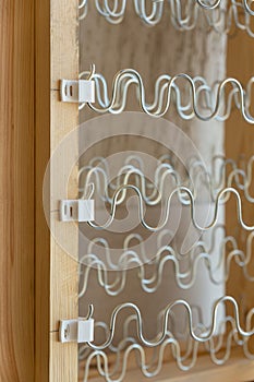 View of spring shock absorbers stretched on a frame inside a modern soft sofa