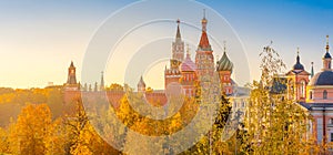 View of St. Basil`s Cathedral and Spassky Tower on Red Square at bright sunset, autumn evening