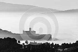 View of St francis church Assisi Umbria Italy above a sea of fog