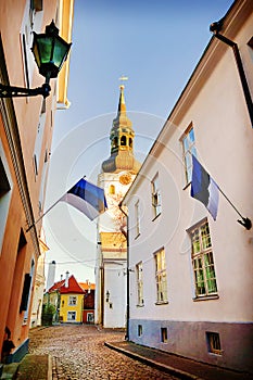View of St.Mary Church and street with Estonian flags. Tallinn.