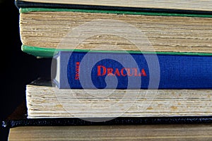 View on stacked old books with blue Bram Stoker Dracula novel in center