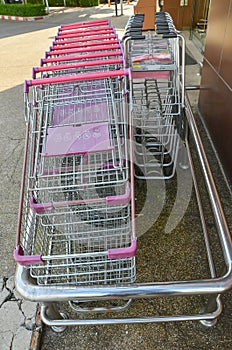 View of stacked supermarket trolley on asphalt floor in storage.