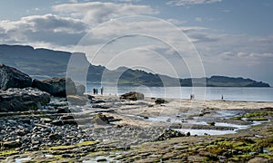 A view of Staffin island and Staffin harbour. Garrafad bay and An Corran Beach. People on the beach searching for dinosaur