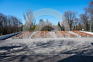 view from the stage to empty benches for spectators in a city park