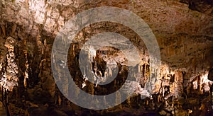 View of stalactites and stalagmites in an underground cavern - Postojna cave, Slovenia