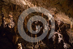 View of stalactites and stalagmites in an underground cavern - Postojna cave, Slovenia