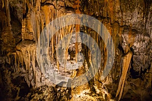 View of stalactites and stalagmites in an underground cavern - Postojna cave, Slovenia