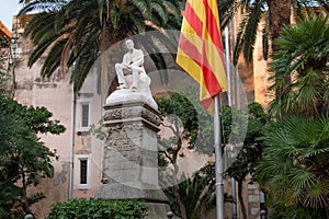View of statue with catalan flag in the spanish town of Sitges in the landmark building of the Ajuntament, known as Casa de la